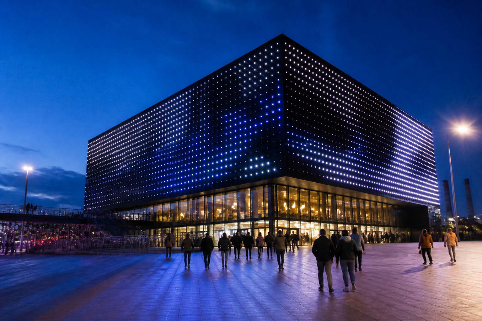 De verlichte buitenkant van de Ziggo Dome tijdens een evenement in de avond laat zien waarom er Ziggo in Ziggo Dome staat.