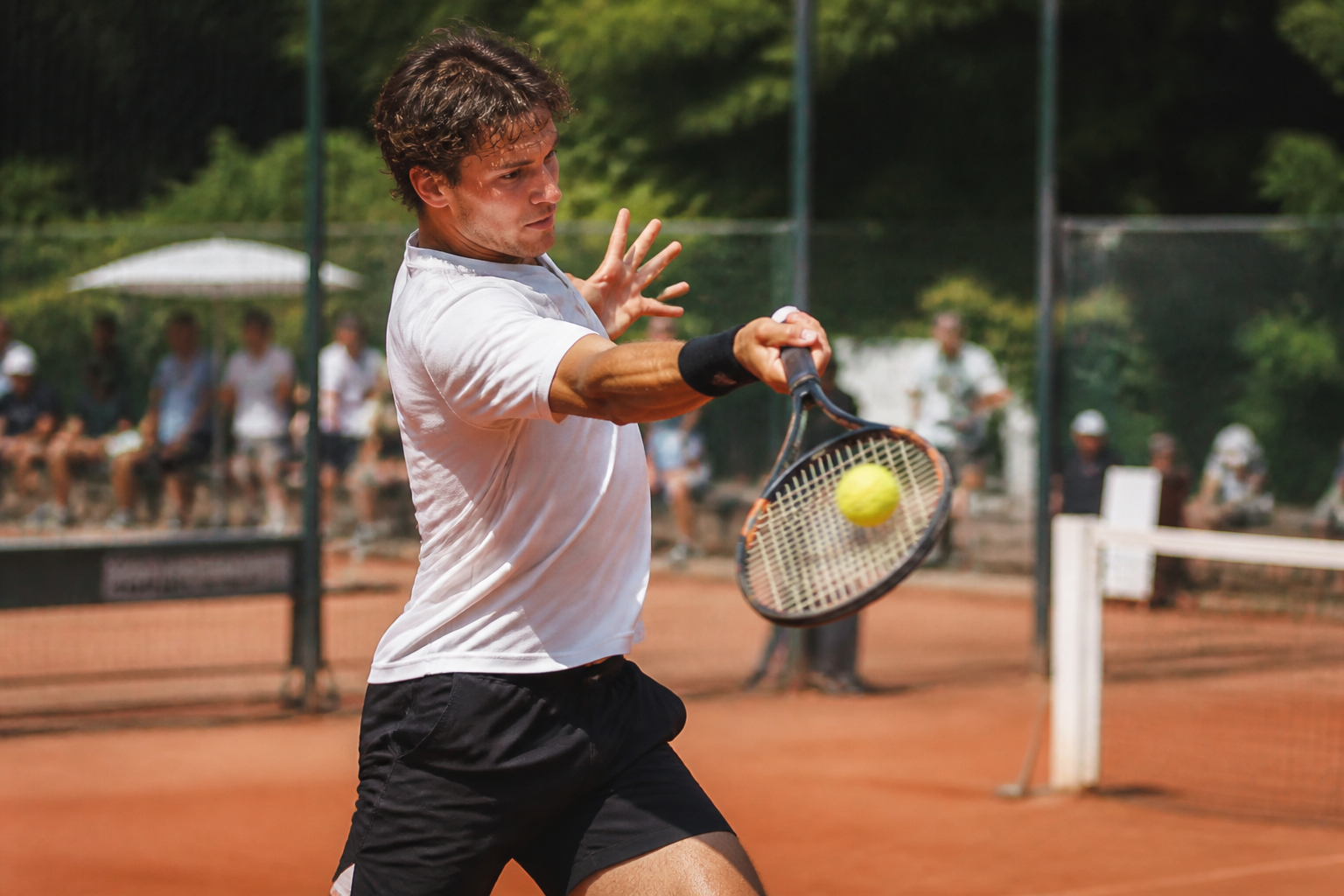 Een tennisser gebruikt een krachtig racket voor een diepe slag vanaf de baseline.