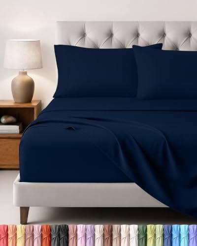Vierdelige Utopia Bedding Beddelakenset in de kleur marineblauw netjes uitgestald op een tweepersoonsbed