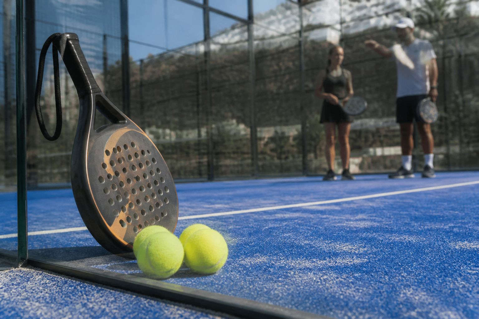 Detailopname van een hoogwaardige padelbaan met racket en ballen in een Spaans sporthotel.